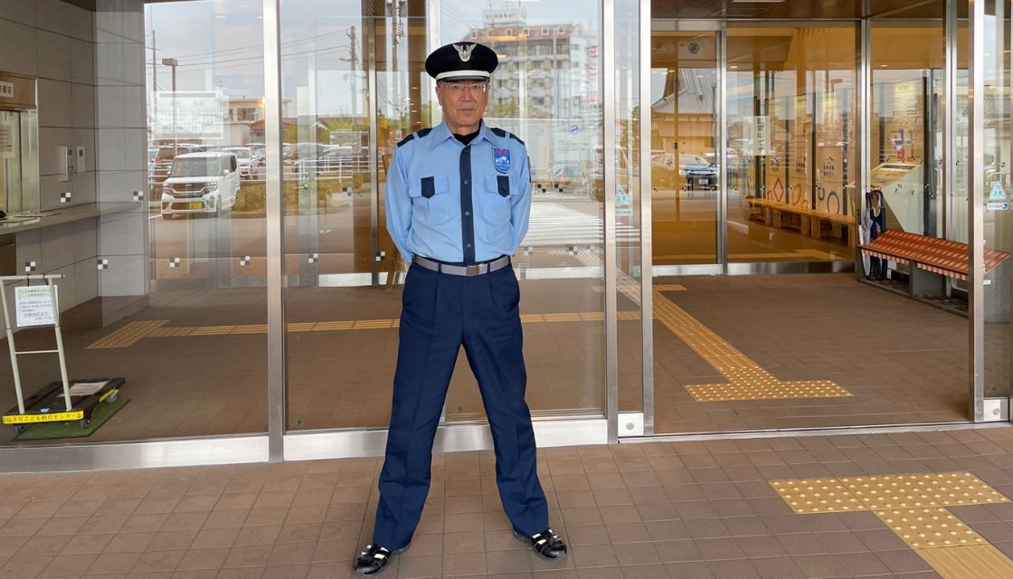 ビルの入口で警備をする男性の写真